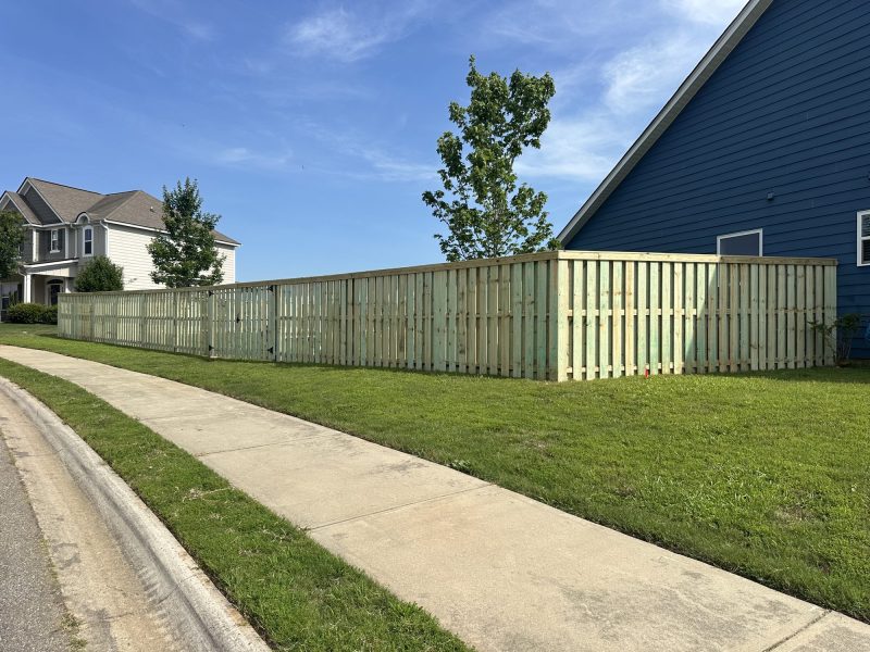 Cream-colored wood picket fence installed along residential property in suburban Aiken or Augusta area neighborhood.