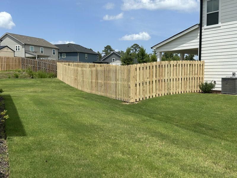 Light-tan wood picket fence installation completing a residential backyard in Aiken area.