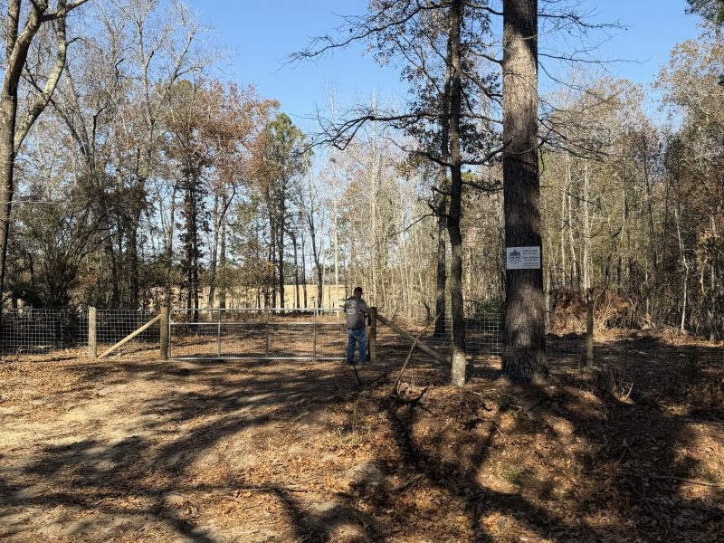 Metal farm gate and chain link fencing installation at rural Aiken property entrance with professional finishing.