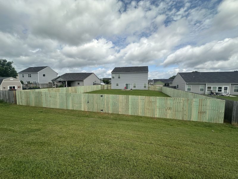 Residential neighborhood with established wood privacy fences in natural weathered finishes separating single-family homes.