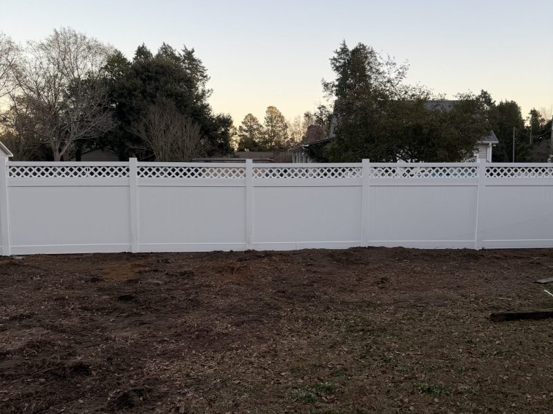 White vinyl privacy fence with lattice top installed in residential yard in CSRA area.