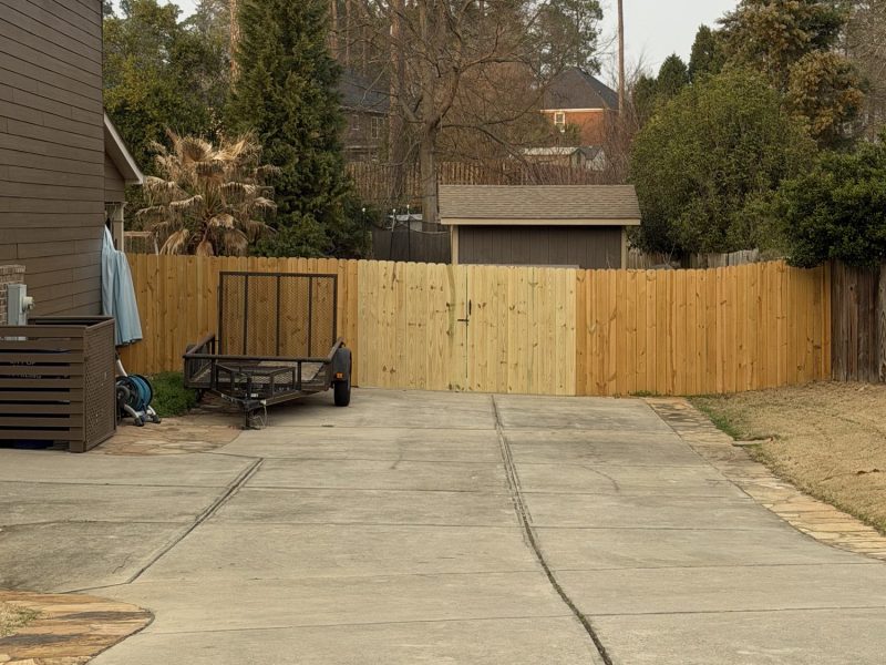 Wood privacy fence installation bordering a residential driveway in a suburban CSRA backyard setting.