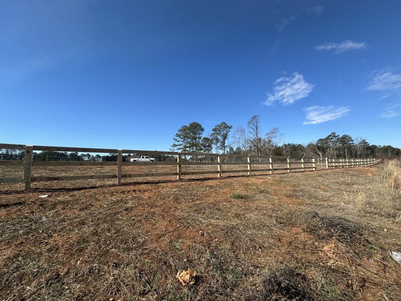 Wooden rail fencing installed across rural property in CSRA, defining pasture boundaries for farm and ranch use.